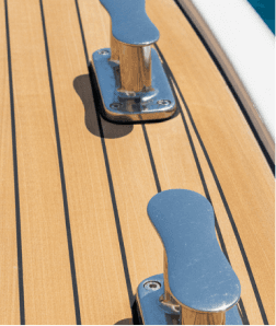 Close-up of a teak yacht deck with polished metal cleats