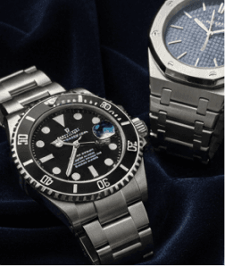 Two luxury wristwatches displayed on dark navy velvet