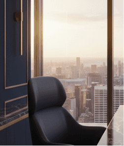 Leather office chair by a floor-to-ceiling window overlooking a city skyline at sunset