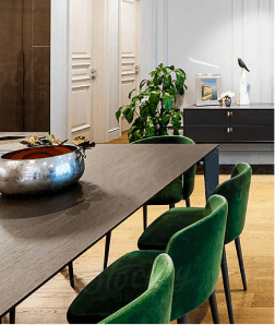 Elegant dining room with a long table and green velvet chairs